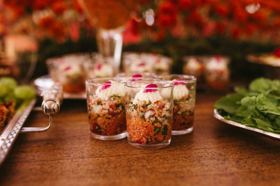 A vibrant display of gourmet appetizers in cups at a wedding reception.